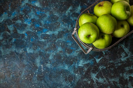 Juicy green organic apples and drops of water on a wooden background. Healthy food. Selective focus. Copy space.の写真素材