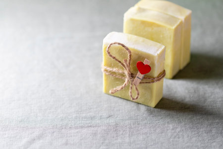 Natural handmade soap with a heart decor on a background of linen fabric.の写真素材