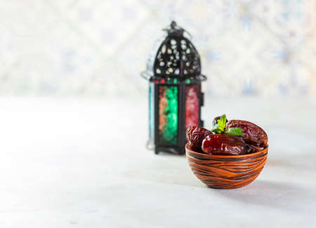 Plate with dates, decorative arabic lantern and rosary on a light background. Holy month of Ramadan concept. Selective focus, copy spacyの写真素材