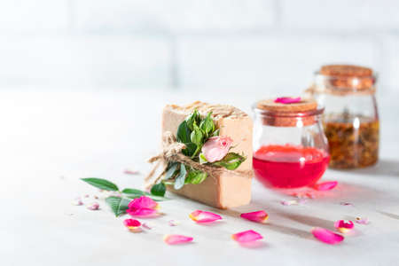 Organic handmade soap, pink rose bud on a white concrete background. Natural and non-waste cosmetic ingredients. Healthy lifestyle concept. Selective focus, copy spaceの写真素材