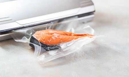 Salmon fillets in a vacuum package. Sous-vide, new technology cuisine. Selective focus, copy spaceの写真素材