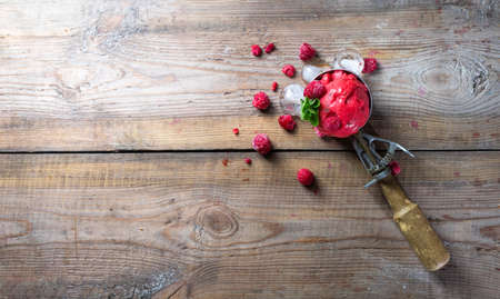 Raspberry sorbet, ice cream on a wooden background. Vintage ice cream spoon. Copy space.の写真素材