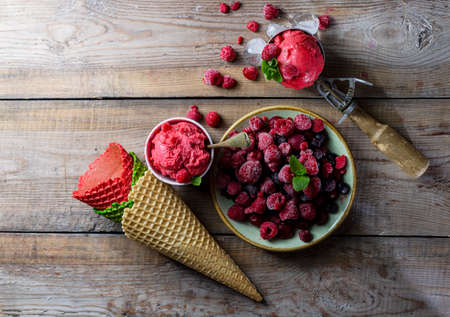 Raspberry sorbet, ice cream on a wooden background. Vintage ice cream spoon. Copy space. Selective focus, top view.の写真素材