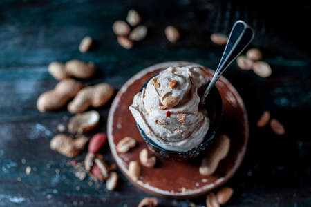 Ice cream with peanuts on a dark background. Summer dessert with nuts. Selective focus, copy space for text.の写真素材