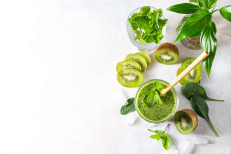 Detox green smoothie - kiwi, spinach and matcha on a light grey slate, stone or concrete background. Selective focus, copy space. Top view.の写真素材