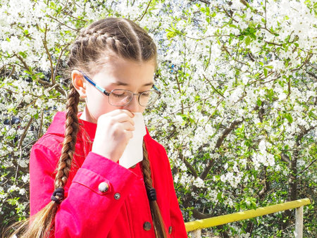 Teen girl suffers from pollen allergy during flowering, uses napkins. Spring allergy concept....