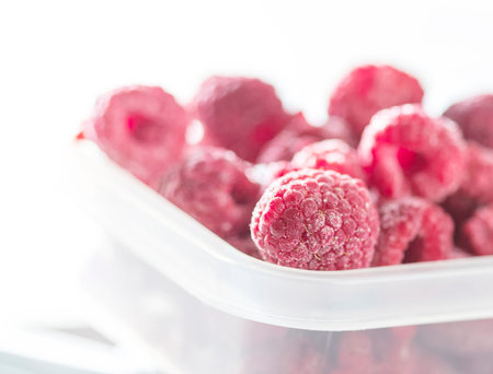 Frozen raspberry close up on a light background. Top view, copy space. Fresh organic berries macro. Selective focusの写真素材