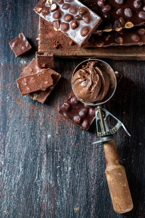 Vintage ice cream spoon and chocolate ice cream on a dark background, top view. Selective focus, copy spaceの写真素材