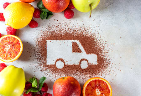 Car made of cocoa powder and citrus fruits on a light background. Online shopping. Healthy nutrition, strengthening immunity. The concept of delivery services, logistics, cargo delivery. Copy spaceの写真素材