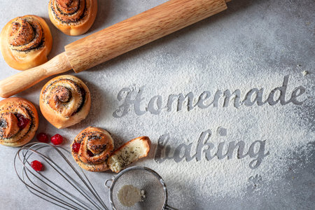 The inscription on the flour Homemade baking. Homemade buns with poppy seeds, tools and baking...
