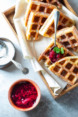 Gluten-free homemade waffles on a light gray concrete background. Selective focus, copy space.