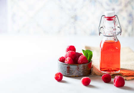 Homemade raspberry vinegar and fresh raspberries. Selective focus, copy spaceの写真素材
