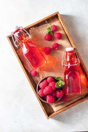 Homemade raspberry vinegar and fresh raspberries. Flat lay for your text.の写真素材