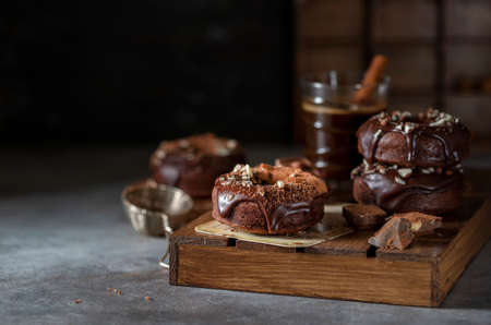 Chocolate donuts with chocolate glaze, nuts and coffee. National Donut Day. Homemade baking. Selective focus, copy spaceの写真素材