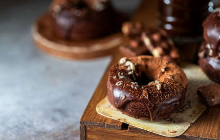 Chocolate donuts with chocolate glaze, nuts and coffee. National Donut Day. Homemade baking. Selective focus, copy spaceの写真素材