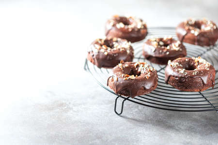 Chocolate donuts on a light concrete background. National Donut Day. Homemade baking. Selective focus, copy spaceの写真素材