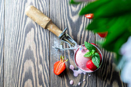 Tasty strawberry ice cream with fresh strawberries on a dark wooden background. Selective focus, copy spaceの写真素材