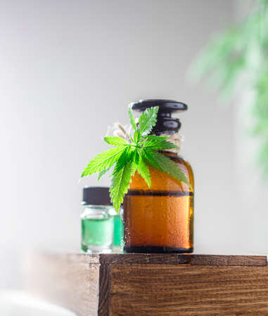 Glass bottles of hemp oil with hemp leaves. Selective focusの写真素材