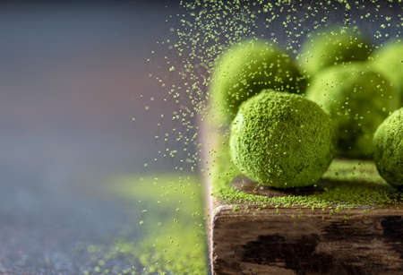 Homemade truffle sweets with matcha green tea on a dark background. Raw energy balls. Selective focus, copy spaceの写真素材