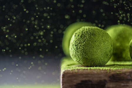 Homemade truffle sweets with matcha green tea on a dark background. Raw energy balls. Selective focus, copy spaceの写真素材