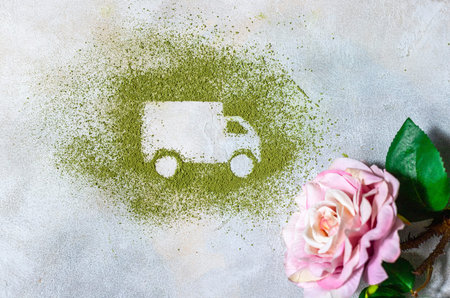Car made of green powder and rose on a light background. Online shopping. Flowers delivery concept....