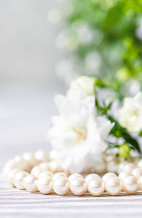 Beautiful white pearl necklace with white flowers. Close up, selective focusの写真素材
