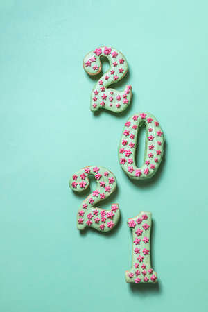 Cookies, gingerbread in the form of New Year's numbers 2021 on a green background. Happy New Year 2021 and Merry Christmas. Winter concept close-up.の写真素材