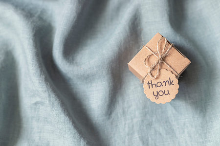 Eco gift box in craft paper branch on linen fabric. Zero waste, plastic free. Flat lay