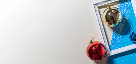 Christmas mirror balls on a shiny background. Hard light with shadows.