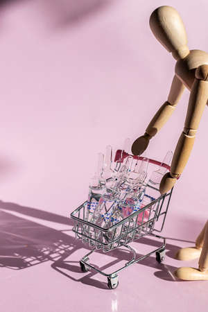 A lot of ampoules for injection in a basket on a pink background. Selling medicines. Online Drug store. Direct hard light with shadows.の写真素材