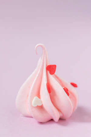 Close-up small pink meringues on a pink background. Handmade. Celebration. Selective focus, copy spaceの写真素材