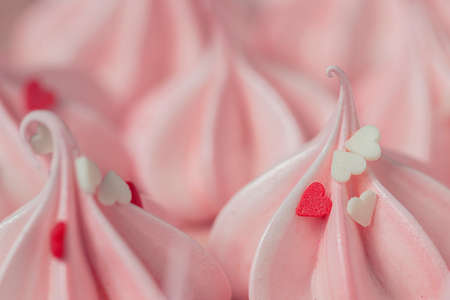 Close-up small pink meringues on a pink background. Handmade. Celebration. Selective focus, copy spaceの写真素材
