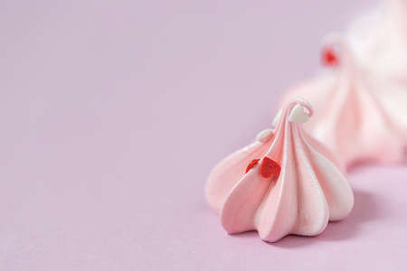 Close-up small pink meringues on a pink background. Handmade. Celebration. Selective focus, copy spaceの写真素材