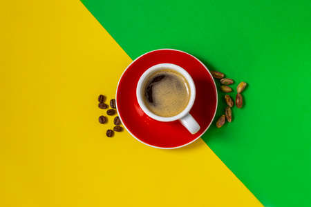 Cup of coffee on yellow and green background, flat layの写真素材