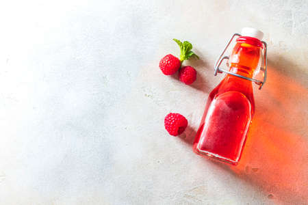 Homemade raspberry vinegar and fresh raspberries. Flat lay for your text.の写真素材