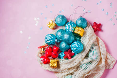 New Year or Christmas. New Year's toys in an environmentally friendly reusable bag on a pink background. Christmas 2020 celebrate, new year concept. Flat lay top view, copy space.の写真素材