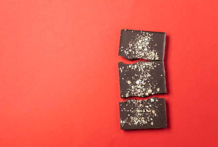 Handmade chocolate bars with berries on a red background. View from above. Copy spaceの写真素材