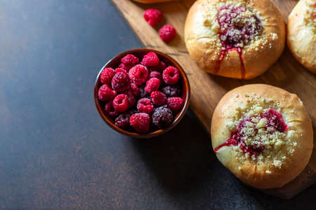 Homemade Sweet Yeast Buns filled with Berry and with crumble on a black background. Copy space, top view.の写真素材
