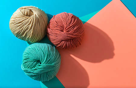 Woolen yarn of different colors on a colored background. Hand knitting. Copy spaceの写真素材
