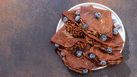 Homemade chocolate crepes with fresh berries and chocolate sauce. Selective focus, copy spaceの写真素材