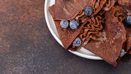 Homemade chocolate crepes with fresh berries and chocolate sauce. Selective focus, copy spaceの写真素材