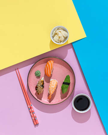 Set of nigiri sushi served on plate on a colorful background. Hard lighting and shadow. Traditional Japanese cuisine.の写真素材