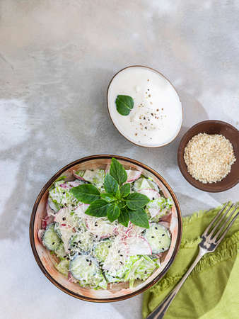 Vegan vegetarian healthy fresh vegetable salad of green lettuce, radish and cucumber and greek yogurt. Healthy vegetarian food. Spring saladの写真素材