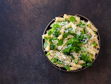 Fusilli with with broccoli, basil and parmesan cheese on a dark background. Proper nutrition. Sports nutrition. Dietary menu. Selective focusの写真素材