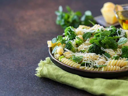 Fusilli with with broccoli, basil and parmesan cheese on a dark background. Proper nutrition. Sports nutrition. Dietary menu. Selective focusの写真素材