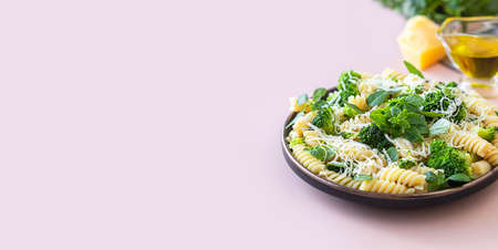 Fusilli with with broccoli, basil and parmesan cheese on beige background. Proper nutrition. Sports nutrition. Dietary menu. Selective focusの写真素材