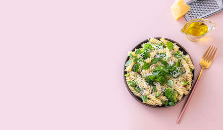 Fusilli with with broccoli, basil and parmesan cheese on beige background. Proper nutrition. Sports nutrition. Dietary menu. Selective focusの写真素材