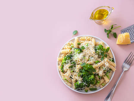 Fusilli with with broccoli, basil and parmesan cheese on beige background. Proper nutrition. Sports nutrition. Dietary menu. Selective focusの写真素材