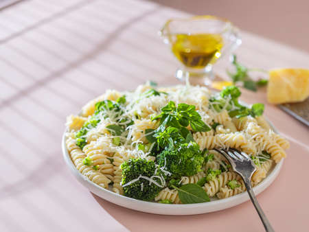Fusilli with with broccoli, basil and parmesan cheese on beige background. Proper nutrition. Sports nutrition. Dietary menu.の写真素材