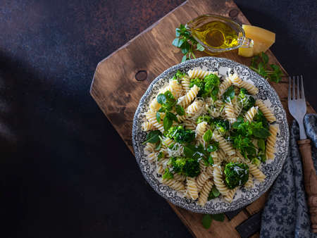 Fusilli with with broccoli, basil and parmesan cheese on a dark background. Proper nutrition. Sports nutrition. Dietary menu. Selective focusの写真素材